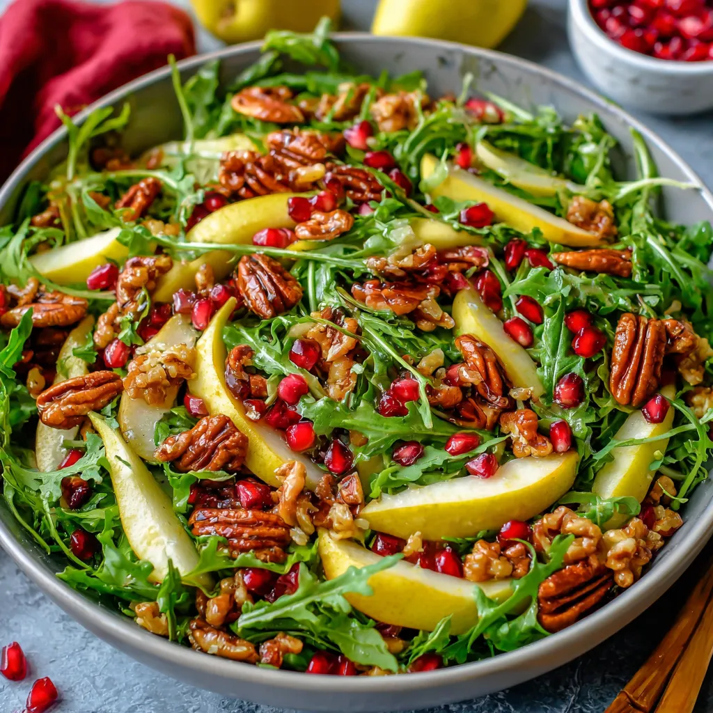 A bowl of salad with apples, pecans, and arugula.