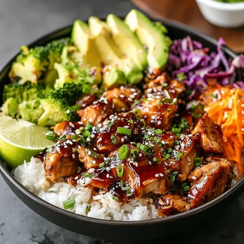 Healthy sticky chicken bowl with honey garlic glazed chicken, rice, broccoli, avocado, shredded carrots, red cabbage and sesame seeds
